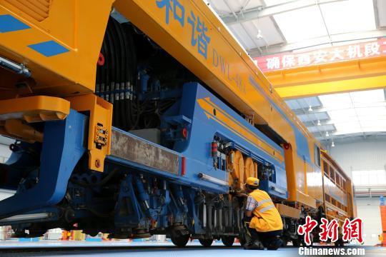 圖為工人正在清理大型養(yǎng)路機(jī)械?！堖h(yuǎn) 攝